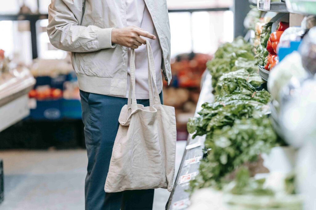 Reusable cloth produce bags filled with bulk grains and vegetables at a grocery store